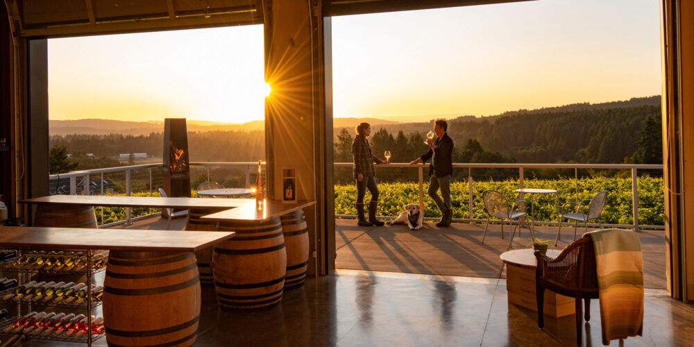 a couple enjoying a glass of wine on a patio at sunset