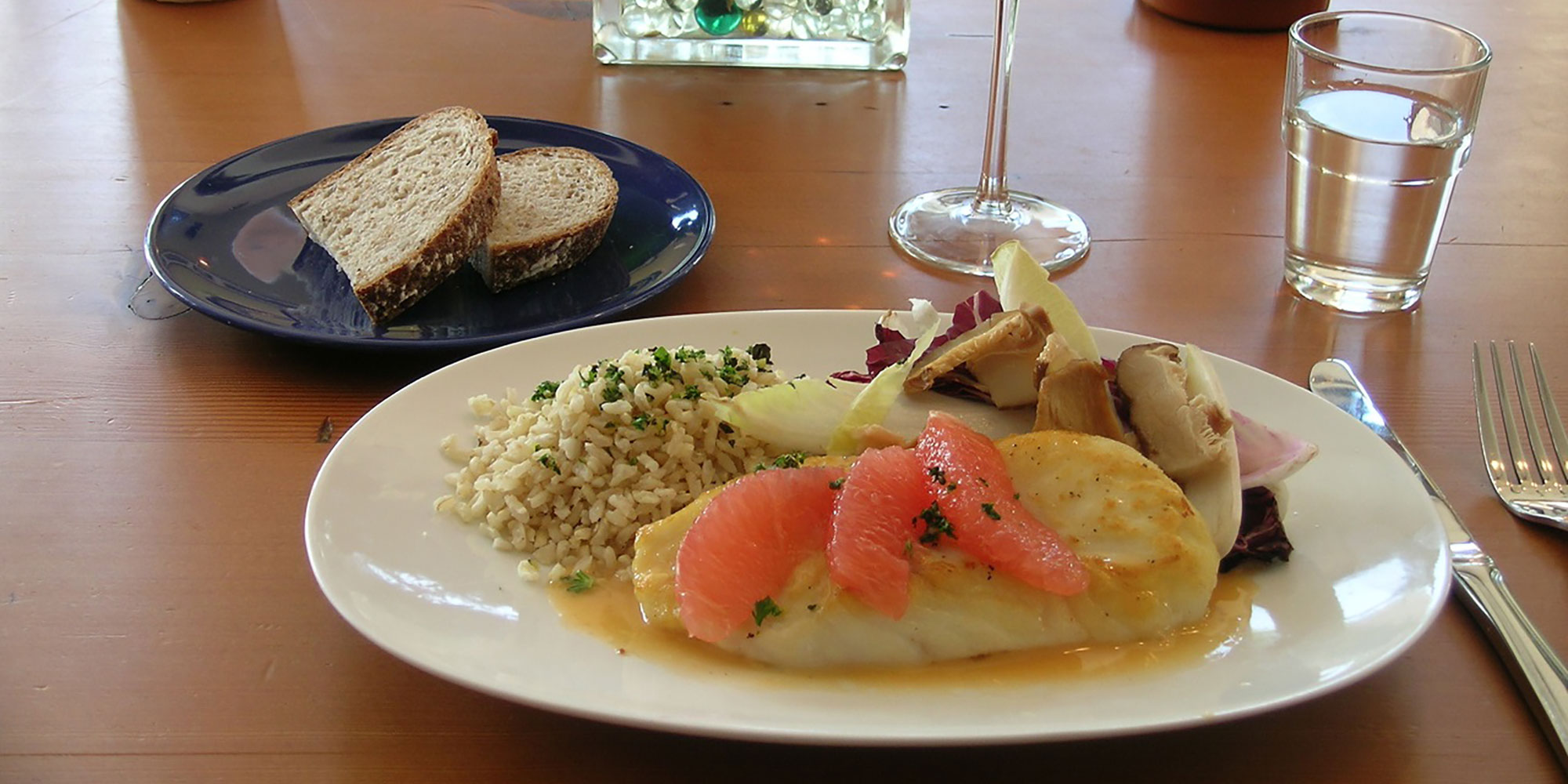 halibut dinner served with fresh bread and wine.