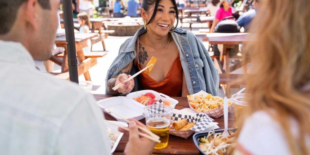 group of friends eating outdoors from food carts